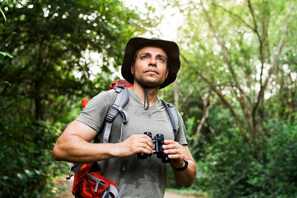 Man holding binoculars in the forest