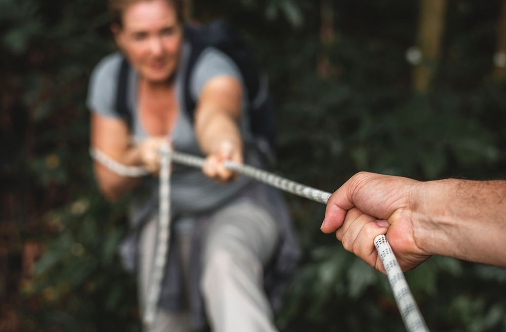 Woman climbing up a rope
