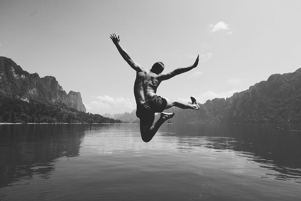 Man jumping with joy by a lake