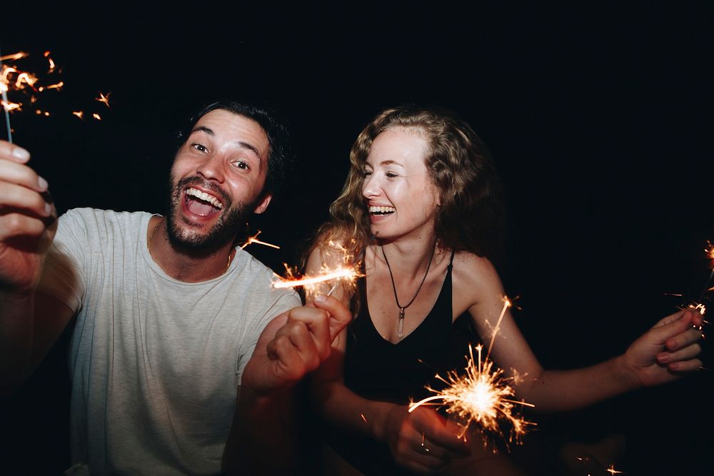 Happy couple with sparklers in the night