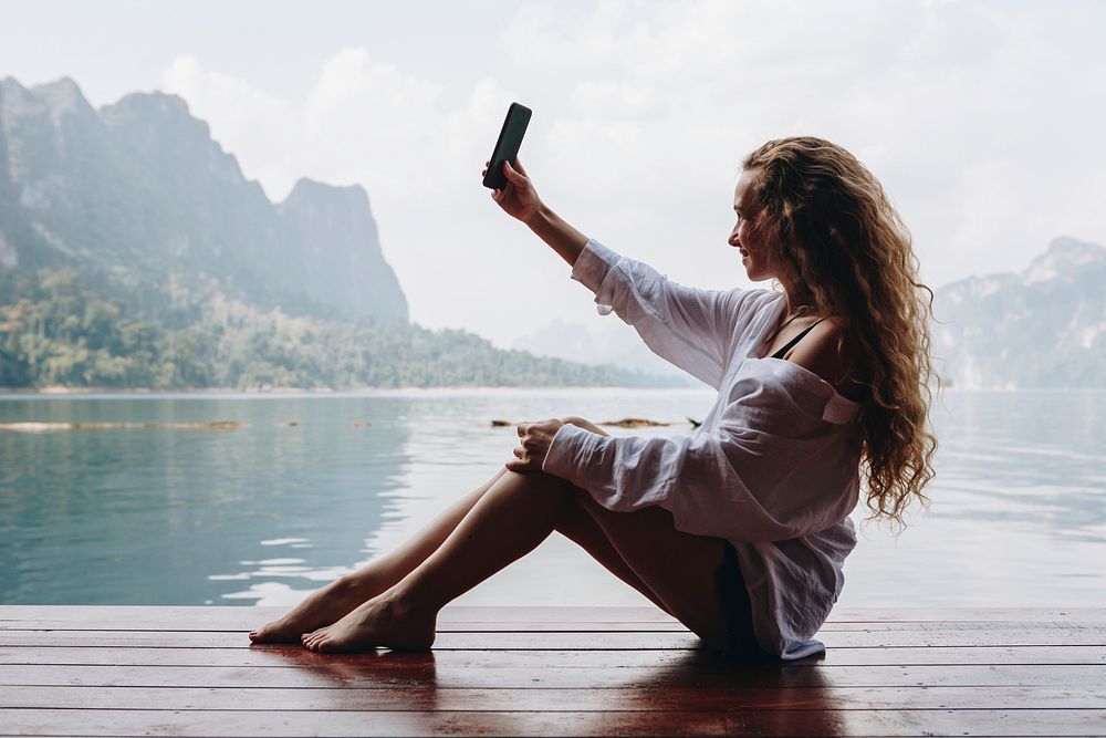 Woman by the water using her phone