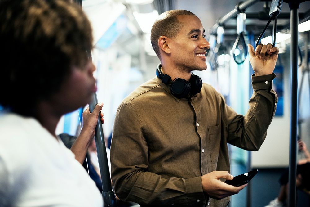 Man riding a train and holding his smartphone