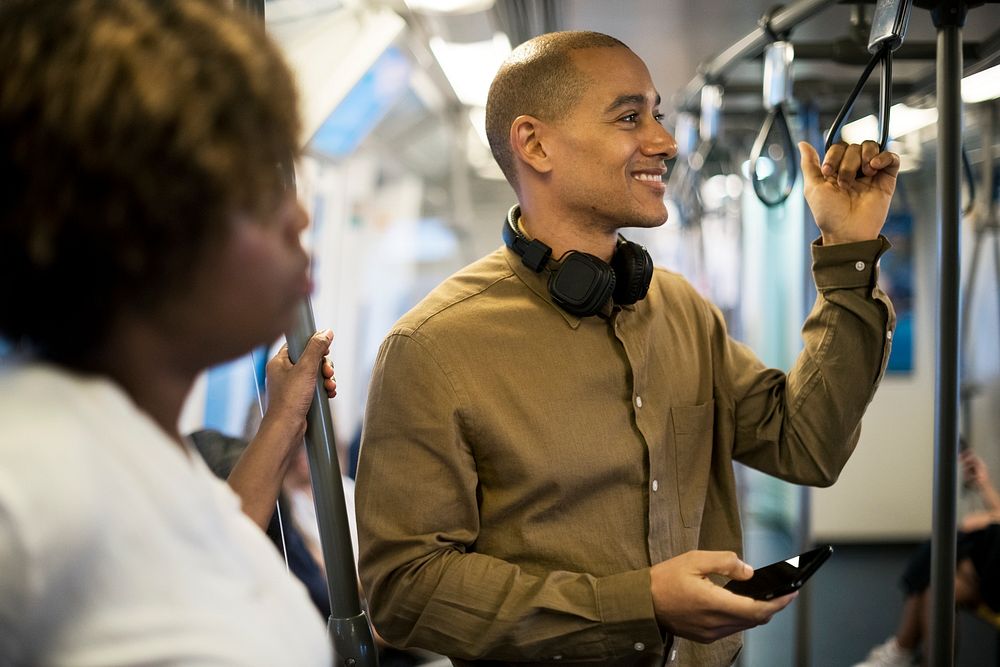 Man riding a train and holding his smartphone