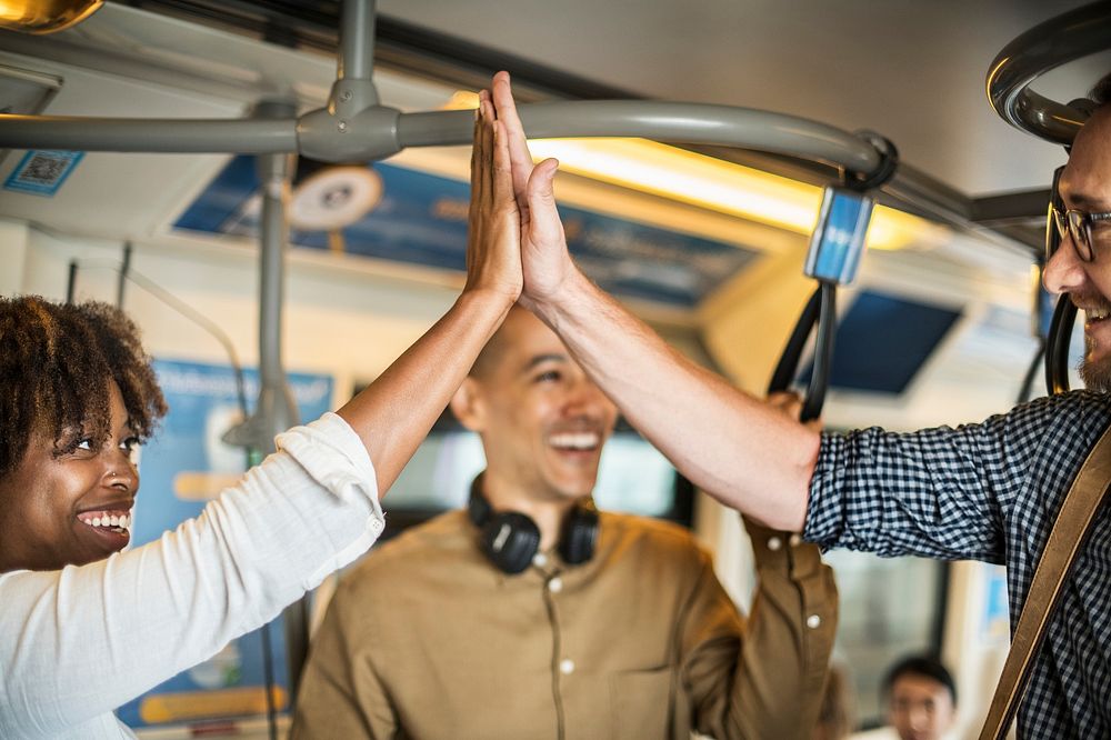 Friends giving a high five on a train