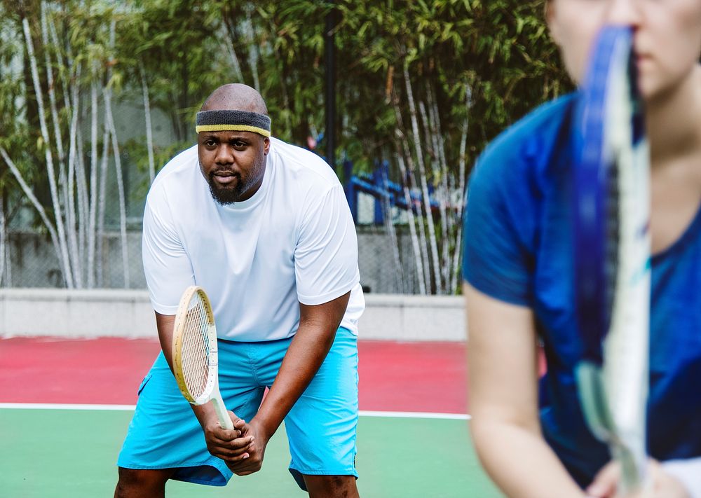 Couple playing tennis as a team