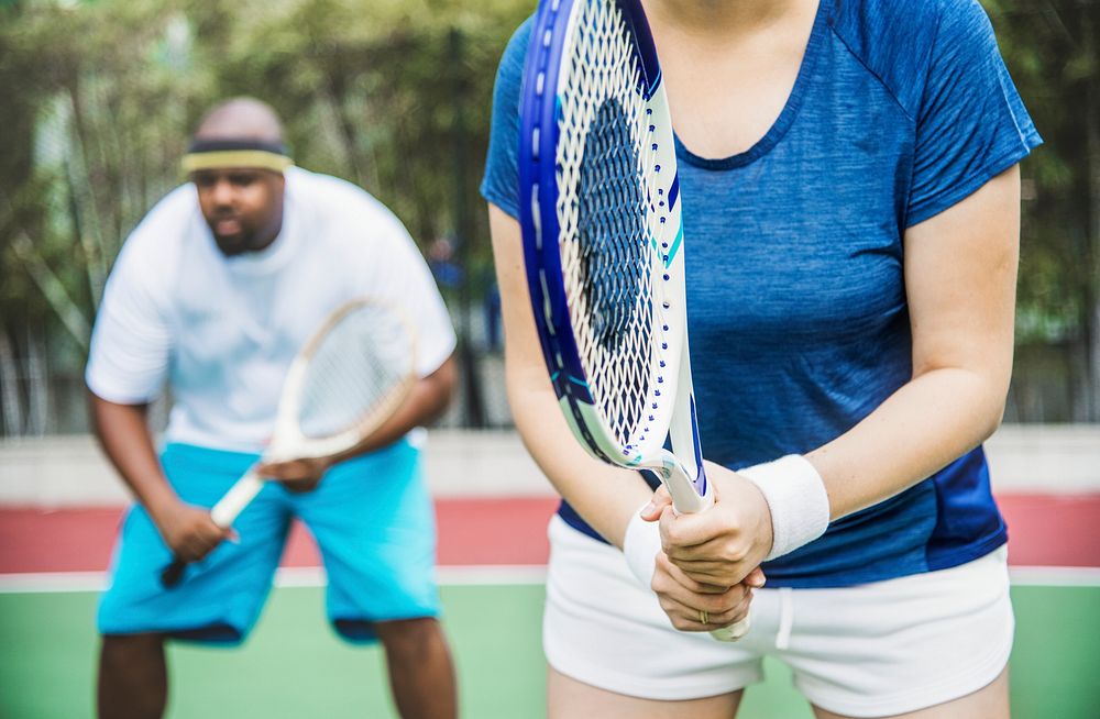 Couple playing tennis as a team