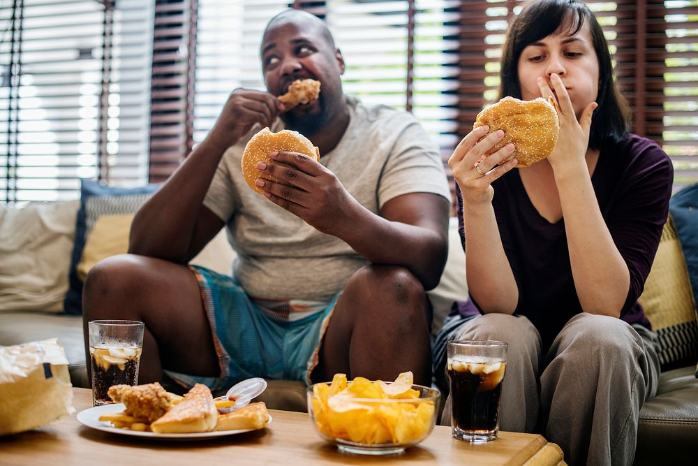 Couple having fast food on the couch