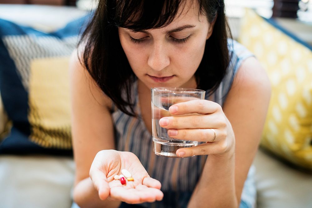Woman taking medication for her illness