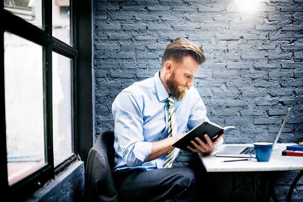 Bearded businessman taking notes