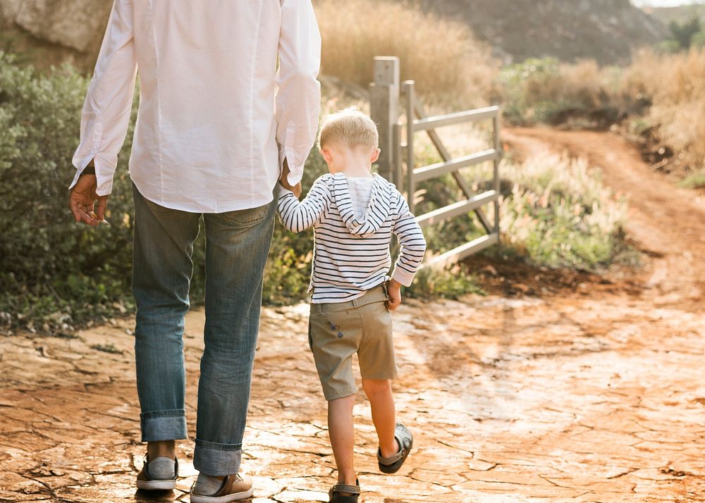 Grandfather and grandson walking at the farm