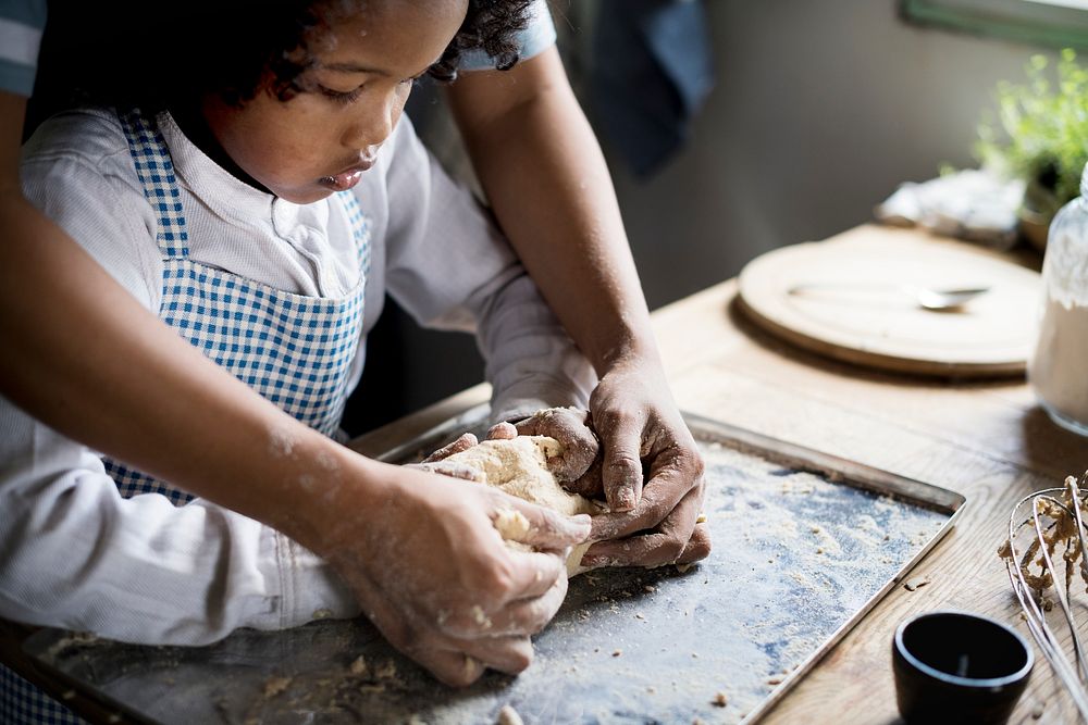 Young boy leaning to bake with his mother