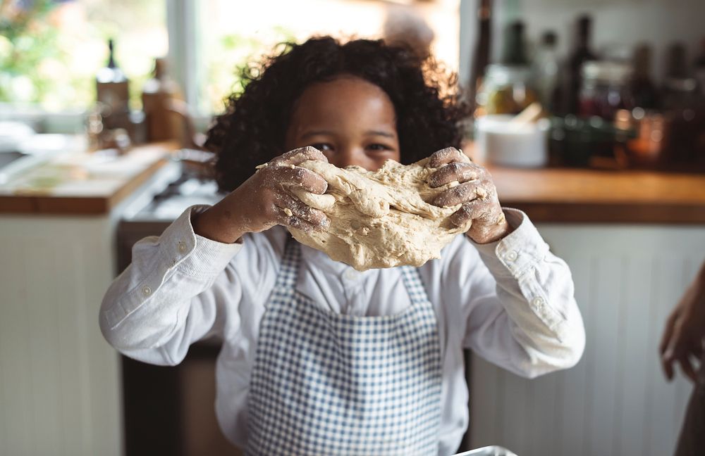 Cheerful boy baking in the kitchen