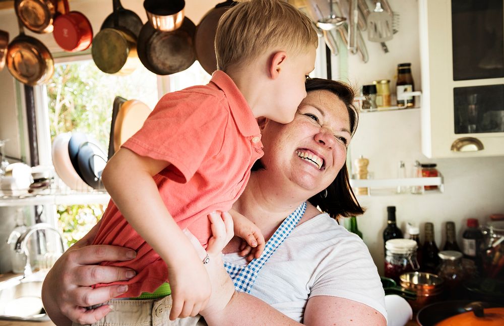 Son kissing his mother in the kitchen