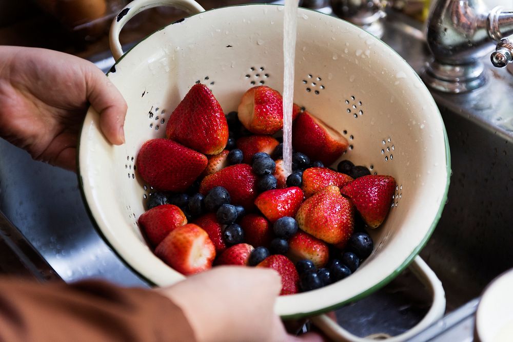 Rinsing fresh strawberries and blueberries