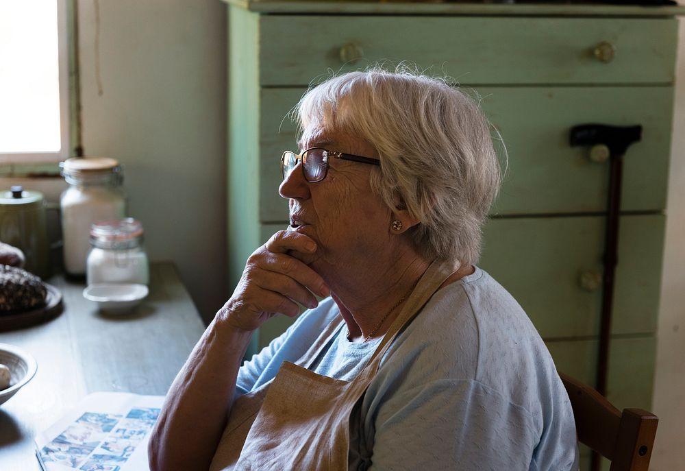 Senior woman sitting alone in her kitchen