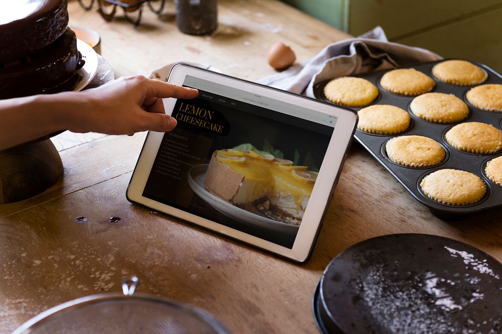 Woman reading lemon cheesecake recipe from a tablet