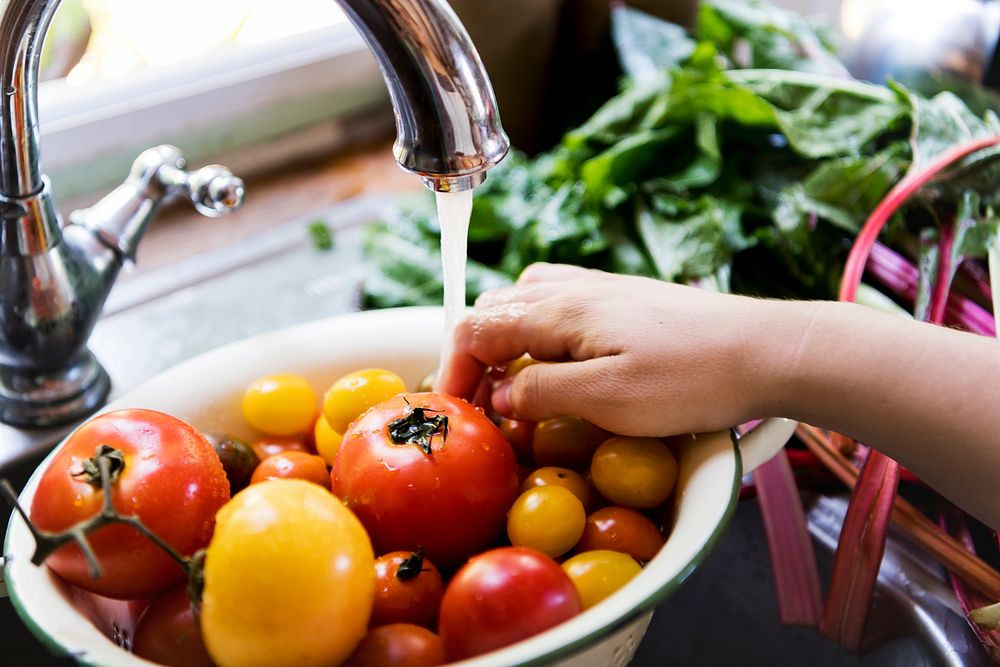 Cleaning tomatoes at a kitchen sink