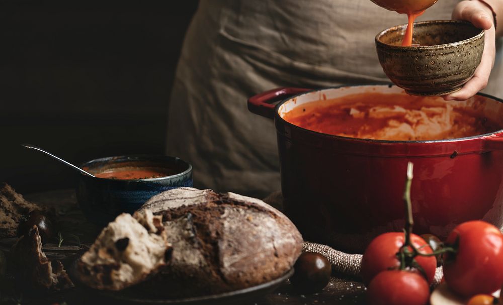 Woman pouring tomato soup into a bowl
