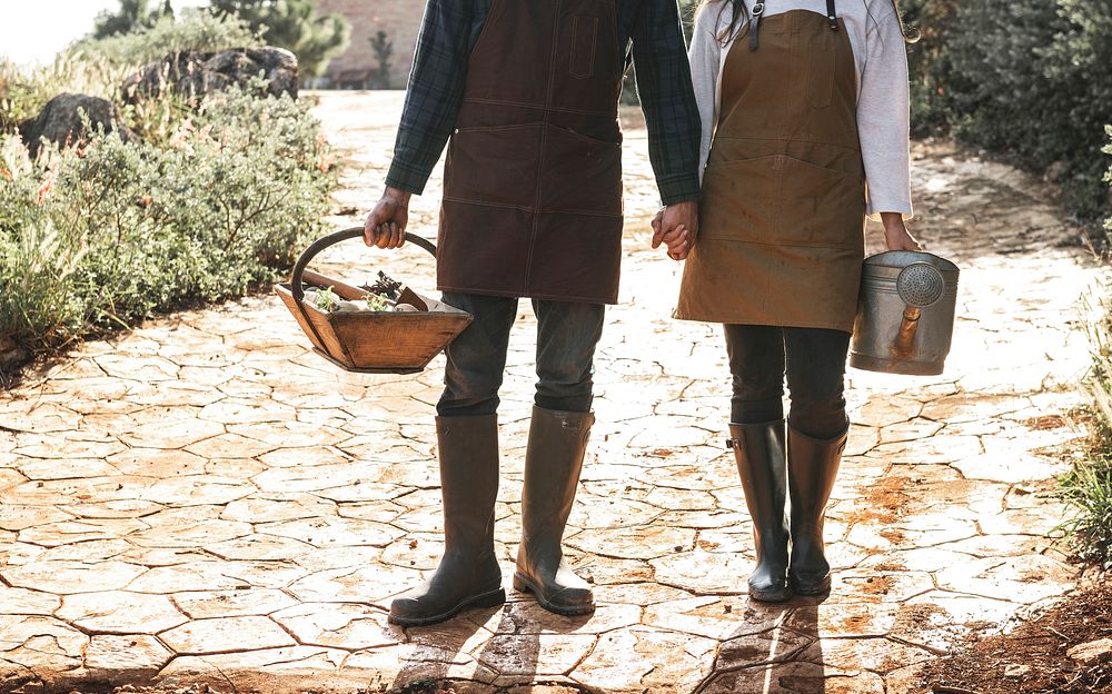 Couple carrying a basket and a watering can
