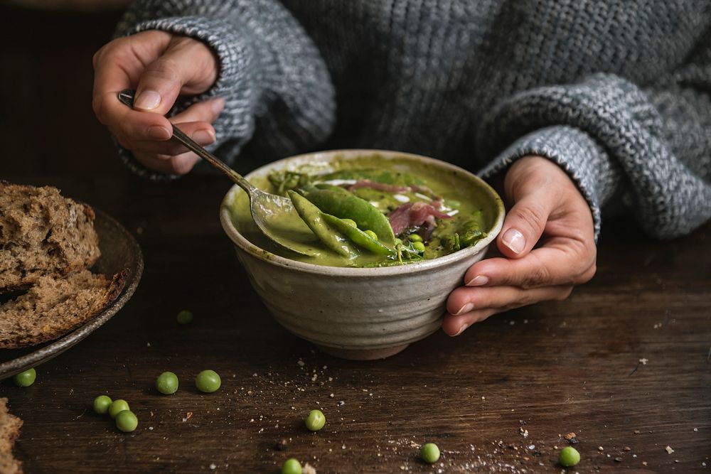 Woman eating a creamy green pea soup