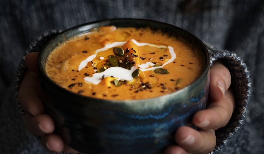 Woman holding a bowl of soup food photography recipe idea