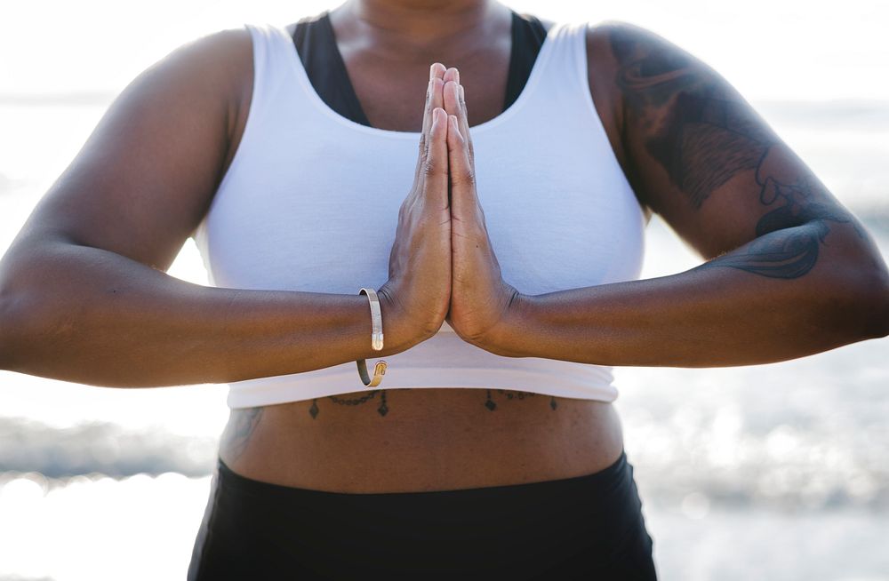 African American woman practicing yoga at the beach