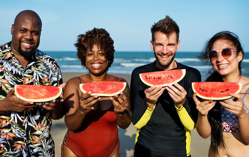 Friends eating watermelon on the beach