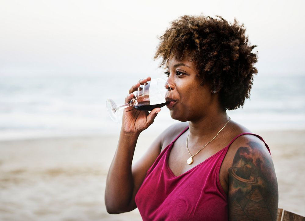 Woman drinking wine on the beach