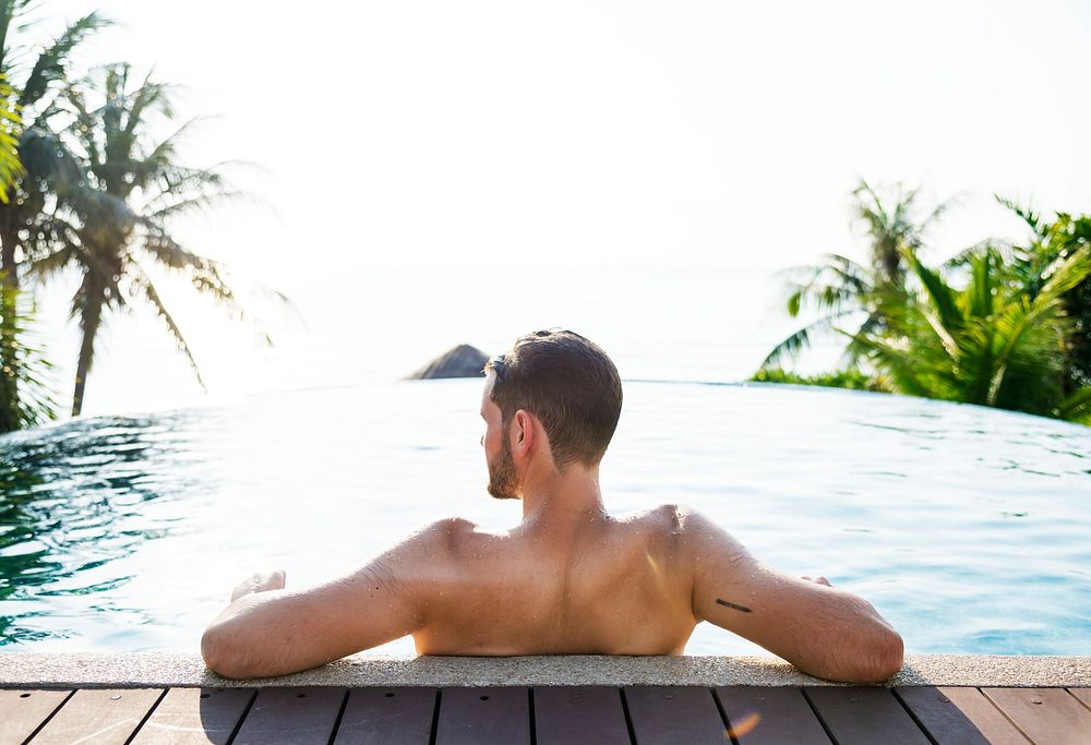 Rear view of man relaxing in a pool
