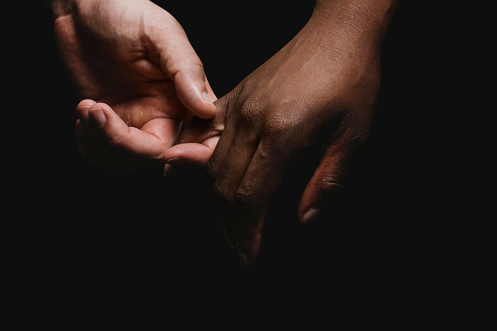 Multiracial psd black and white couple holding hands closeup