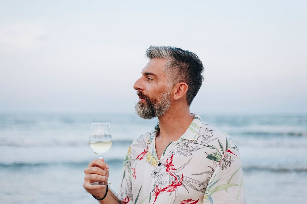 Man drinking a glass of wine by the beach