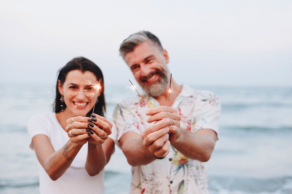 Couple celebrating with sparklers at the beach