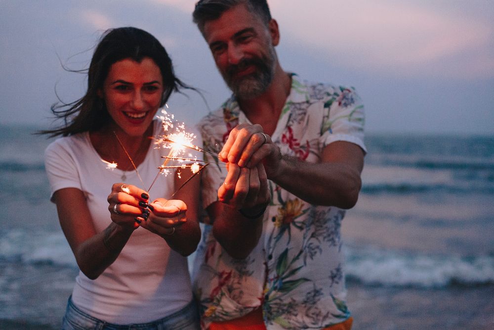 Couple celebrating with sparklers at the beach