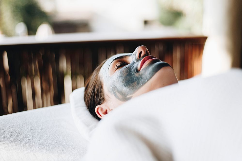 Woman relaxing with a facial mask at the spa