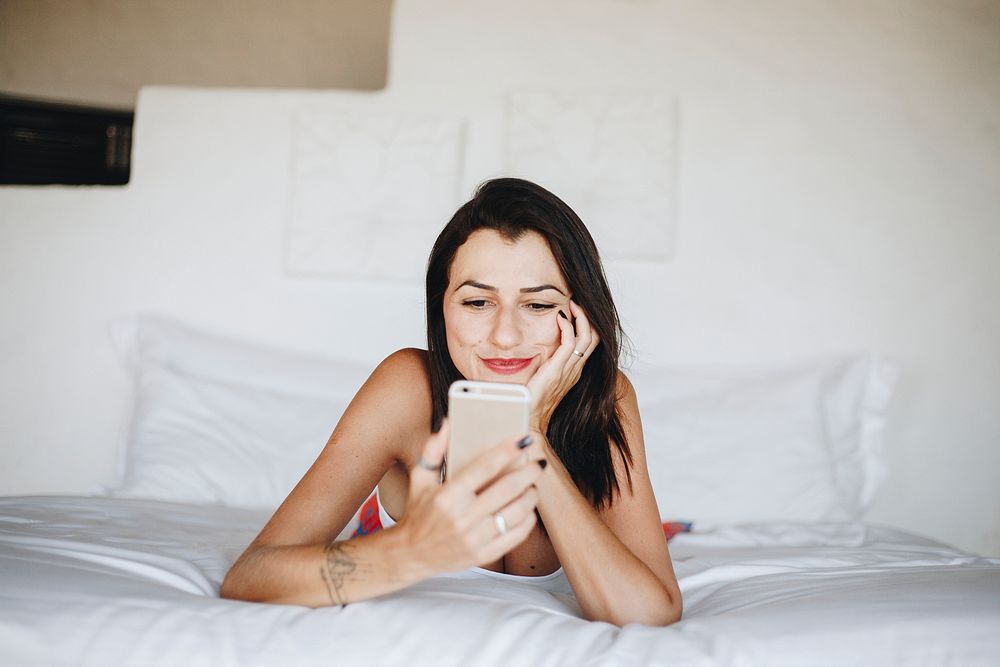 Woman using a mobile phone in bed