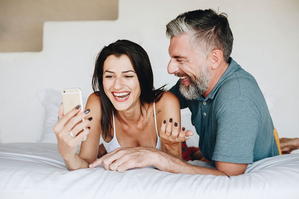 Couple using a smartphone in bed