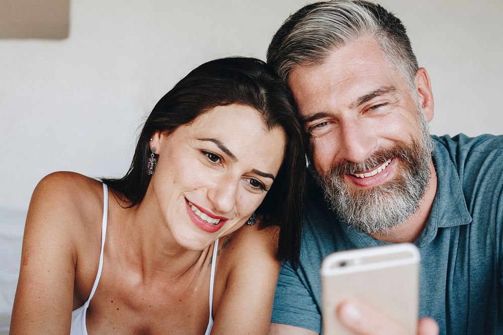 Couple using a smartphone in bed