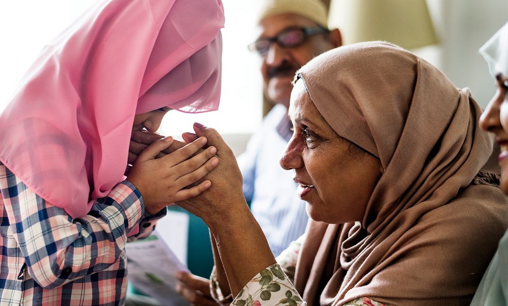 Muslim daughter kisses her mother's hands