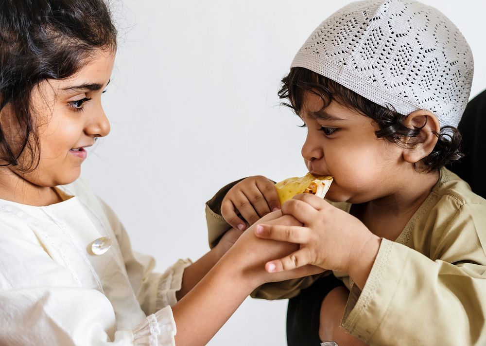 Sister sharing pita bread with her brother