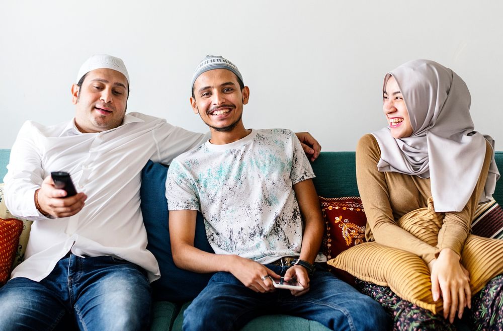 Muslim family watching tv at home