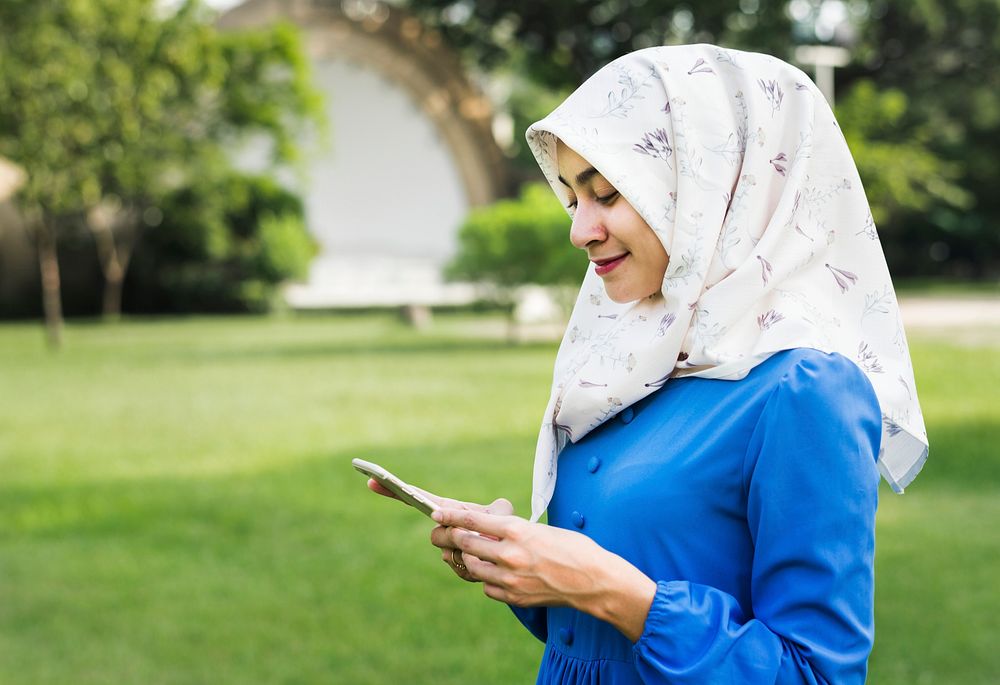 Muslim woman using a smartphone in the park