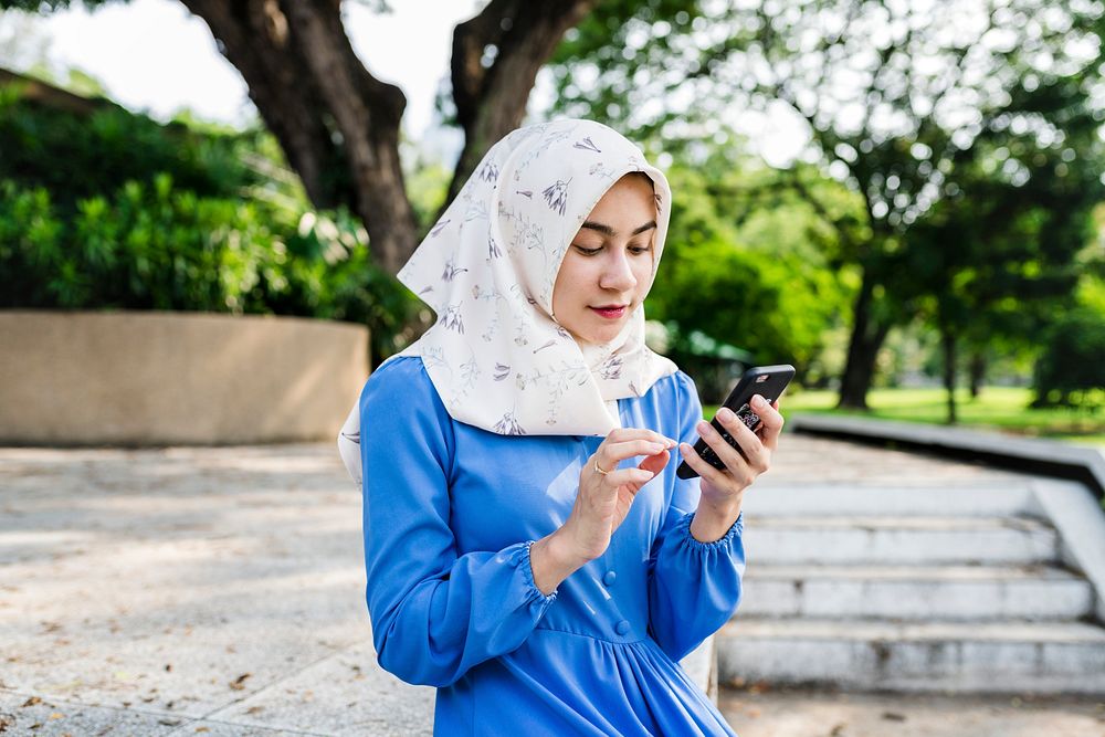 Muslim girl using a smartphone in the park