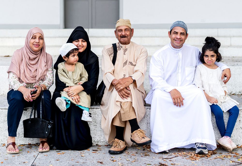 Muslim family sitting together outdoors