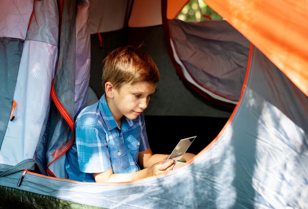 Little boy camping in the forest
