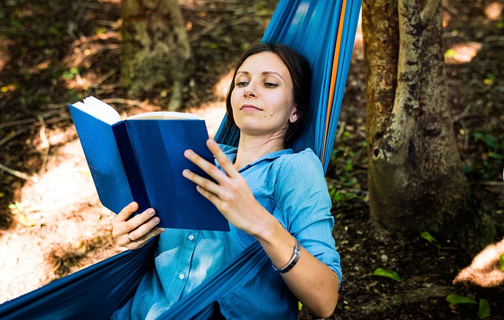 Woman reading a book in a hammock