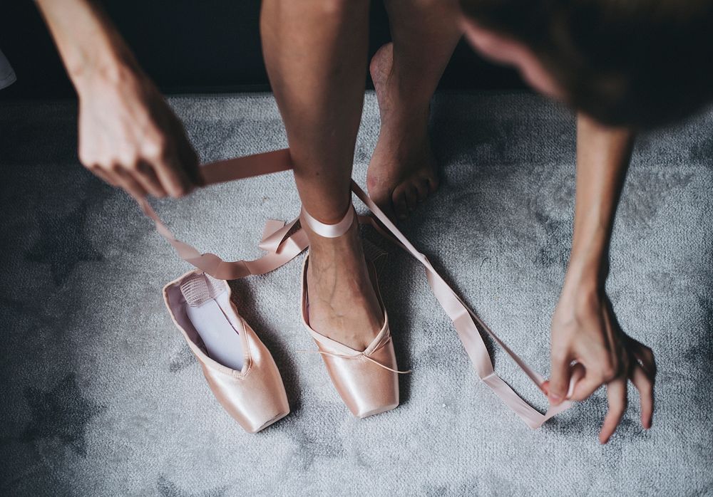 Putting on pink ballet shoes
