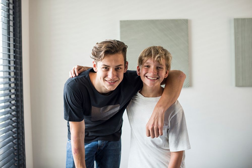 Portrait of cheerful brothers with arms around each other