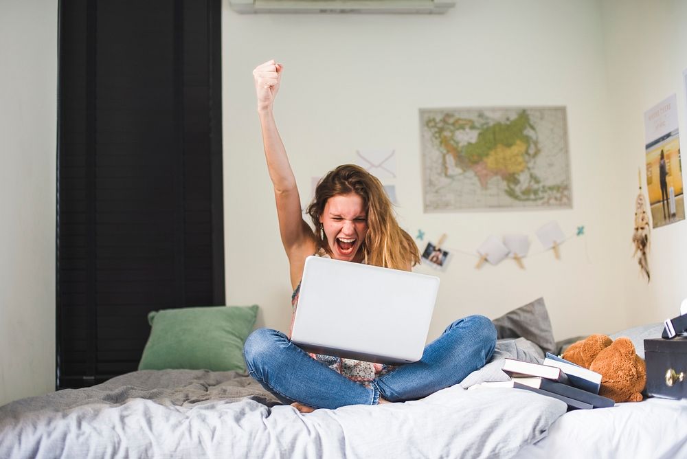 Girl using a laptop with her fist in the air