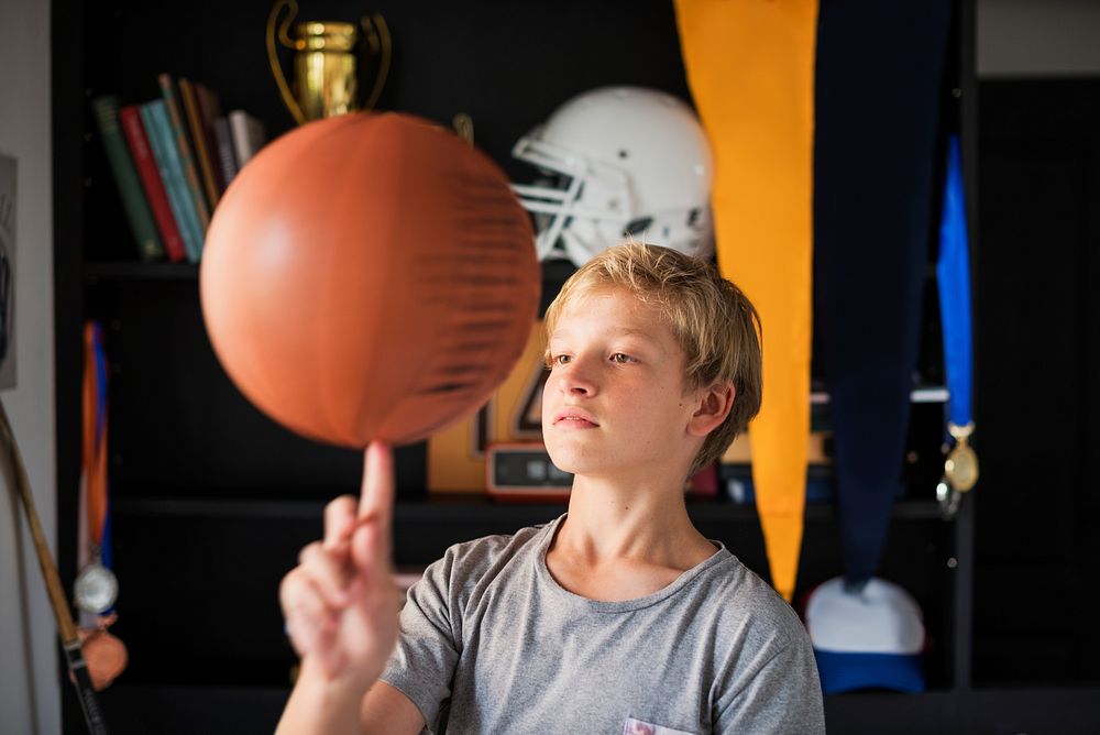 Young boy spinning a basketball on the tip of his finger