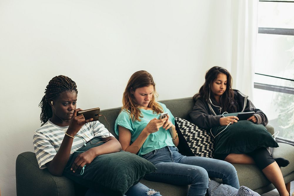 Diverse girls sitting on the couch with their phones
